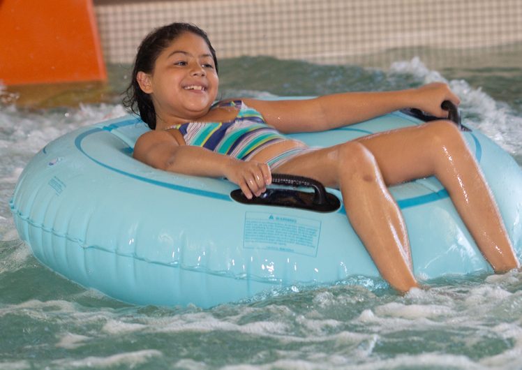 Girl floating on innertube in pool